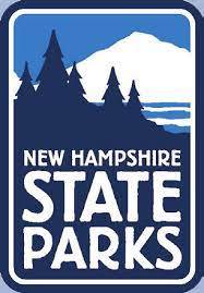 Logo for New Hampshire State Parks featuring silhouettes of pine trees and a mountain in blue and white, with the text New Hampshire State Parks in bold letters.